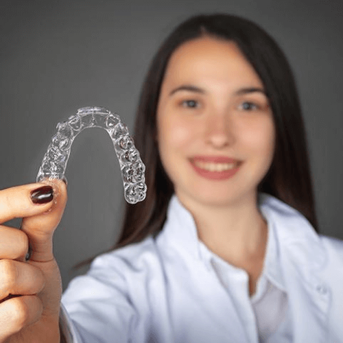 A woman holding her Removable braces in Manchester