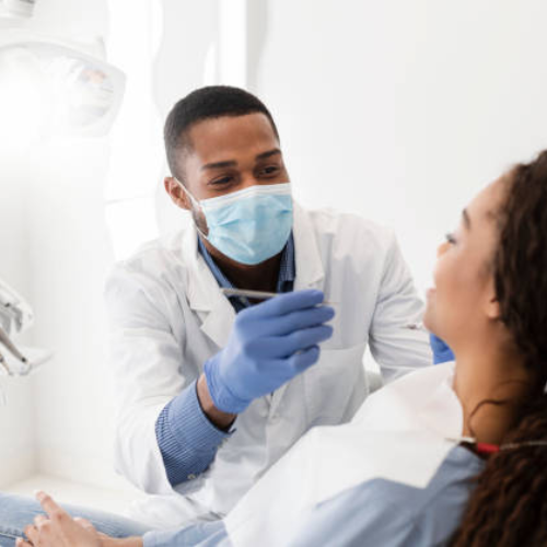 Male orthodontist giving treatment to a woman at Heaton Mersey Orthodontic Centre, Manchester.