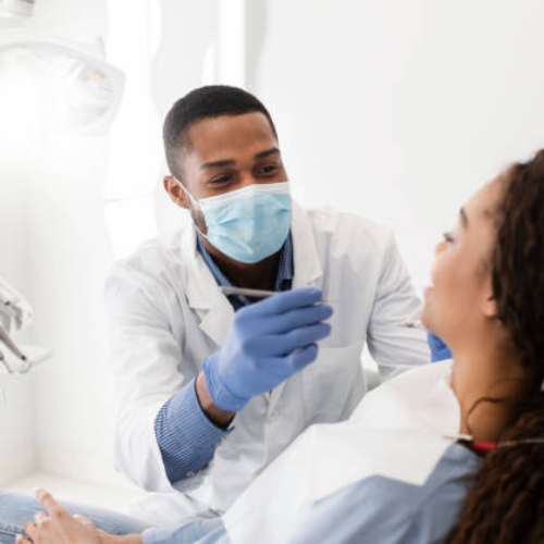 Male orthodontist giving treatment to a woman in Manchester