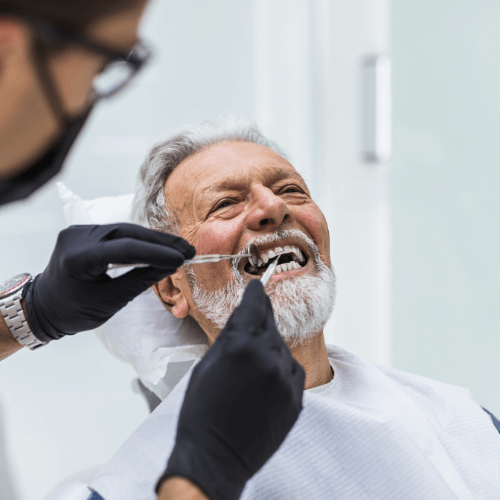 NHS dentist with patient in Manchester, performing a dental check up on a man.