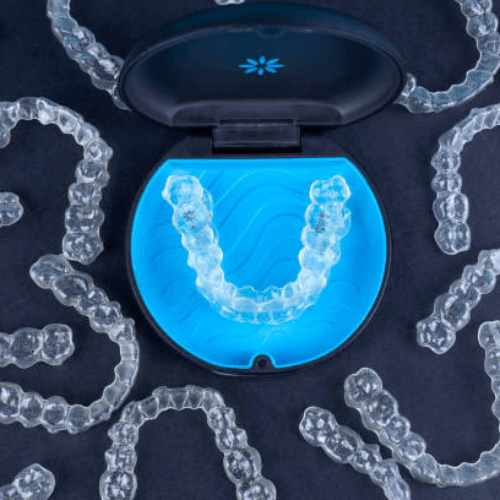 Invisalign aligners in a case, with multiple aligners laying around the case, in Manchester