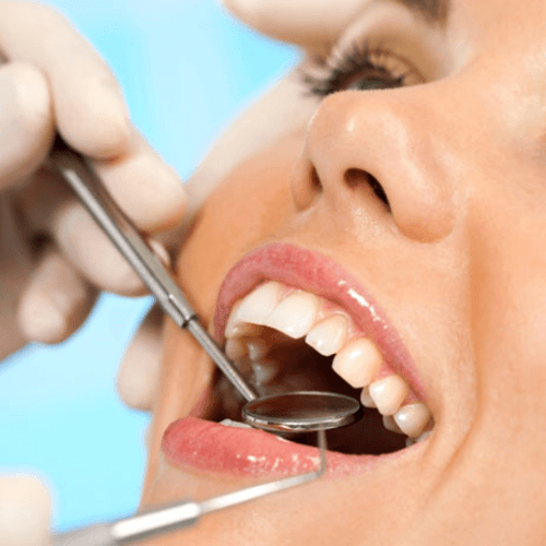 woman at an orthodontist appointment in manchester with dental tools in her mouth.