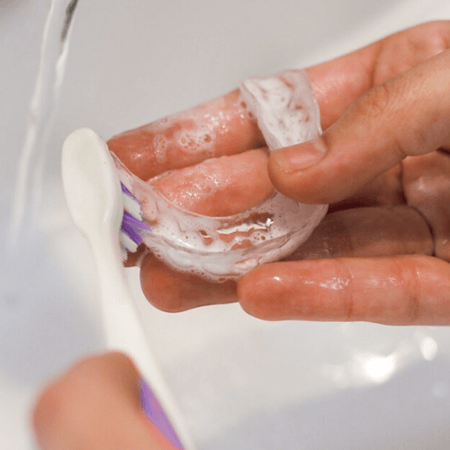 using a toothbrush to clean invisalign aligners