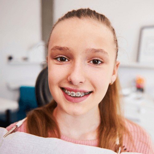 Young girl with NHS braces smiling at the camera at Heaton Mersey Orthodontic Centre.
