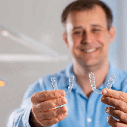 man holding two clear aligners