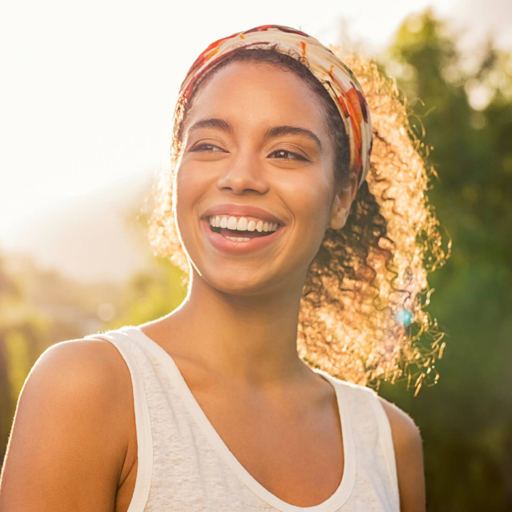 woman with a straight bright white smile with her invisalign clear aligners in