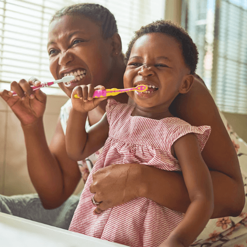 mum brushing her teeth alongside her young daughter. Children dental health