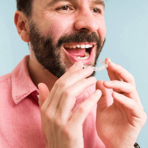 man putting in his invisalign clear aligners