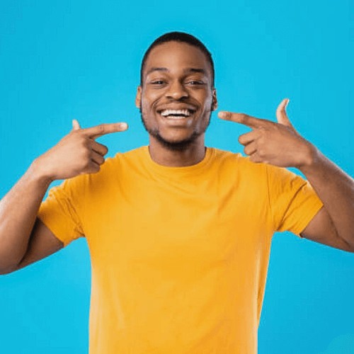 man with perfect straight teeth pointing at his smile