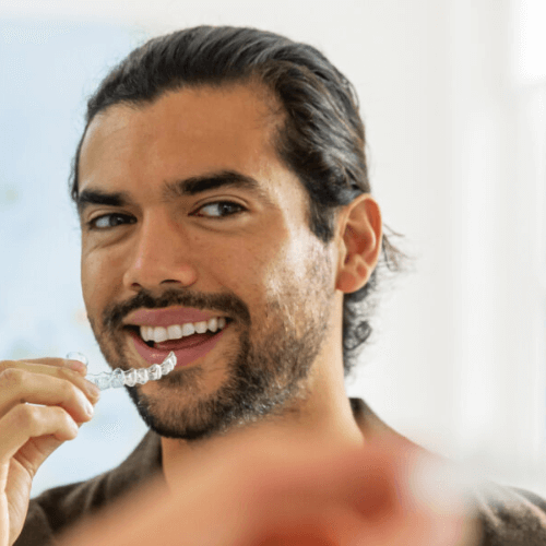 man putting in his clear invisalign braces in Stockport